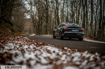 Tesla Model 3 2025 – rear view, dark grey on a snowy country road