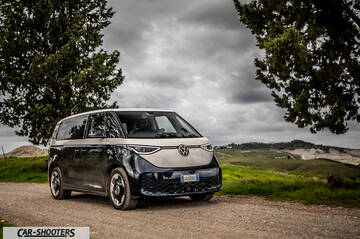 Volkswagen ID BUZZ – front three-quarter, blue and beige on a country road