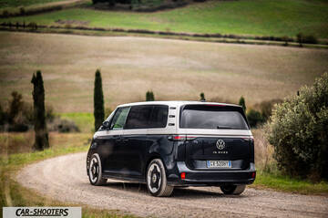 Volkswagen ID BUZZ – rear three-quarter, dark blue and silver on a country road
