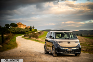 Volkswagen ID BUZZ – front three-quarter, beige and dark blue on a country road