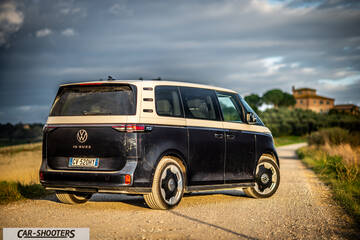 Volkswagen ID BUZZ – rear three-quarter, dark blue and white on a country road