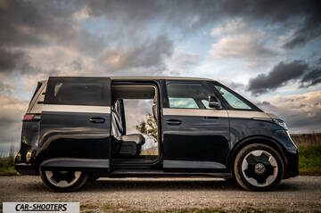 Volkswagen ID BUZZ – side profile, black and beige on a gravel road