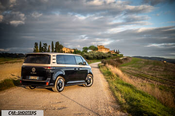Volkswagen ID BUZZ – rear three-quarter, dark blue and silver on a country road