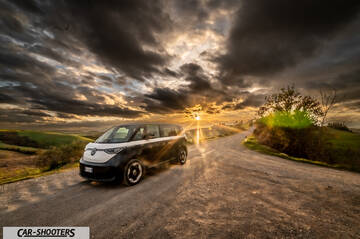 Volkswagen ID BUZZ – front three-quarter, black and white on a dirt road at sunset