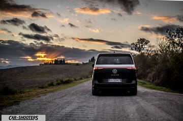 Volkswagen ID BUZZ – rear view, black on a gravel road at sunset