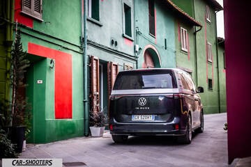Volkswagen ID BUZZ – rear three-quarter, dark grey on a narrow street