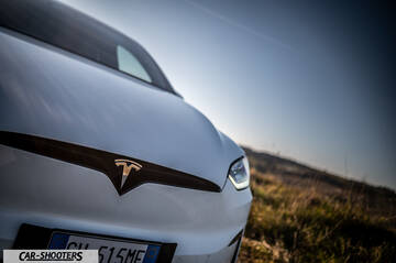 Tesla Model X – front three-quarter, white against a blurred landscape backdrop