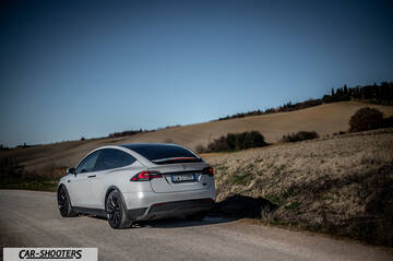 Tesla Model X – rear three-quarter, silver on a country road