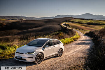 Tesla Model X – front three-quarter, white on a winding country road