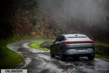 Polestar 4 – rear three-quarter, grey metallic on a wet winding road