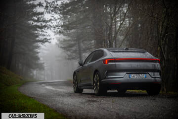 Polestar 4 – rear three-quarter, grey metallic on a country road