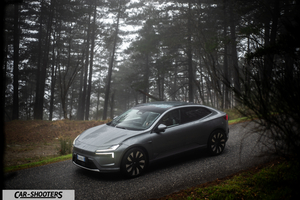Polestar 4 – front three-quarter, grey metallic on a forest road
