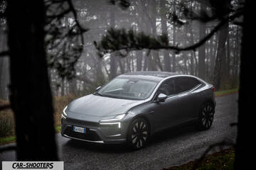 Polestar 4 – front three-quarter, grey metallic on a wet mountain road