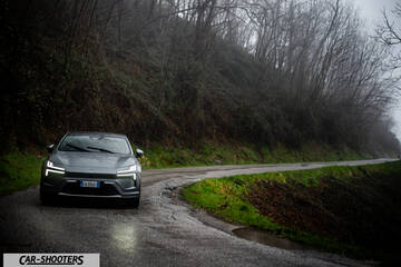 Polestar 4 – front three-quarter, grey on a winding country road
