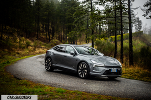 Polestar 4 – front three-quarter, grey metallic on a winding country road