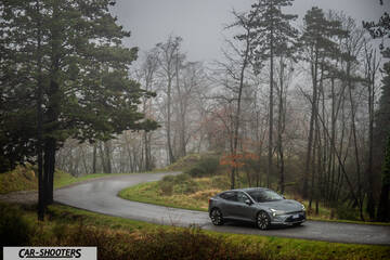Polestar 4 – front three-quarter, grey metallic on a winding road
