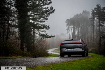 Polestar 4 – rear view, grey on a wet winding road