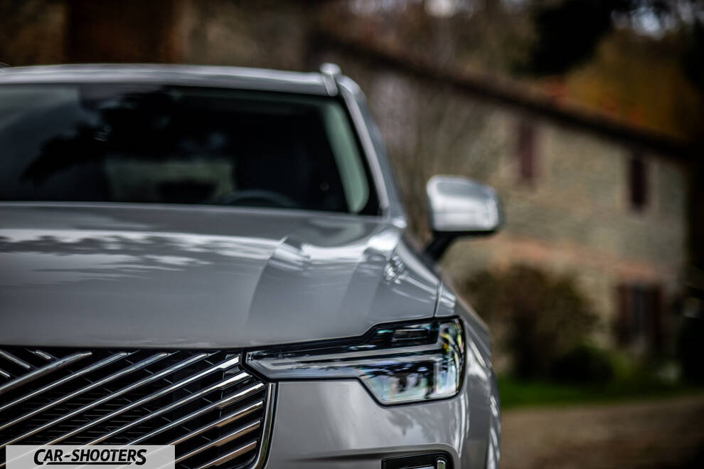 Volvo XC90 2025 – front three-quarter, silver parked near old stone building