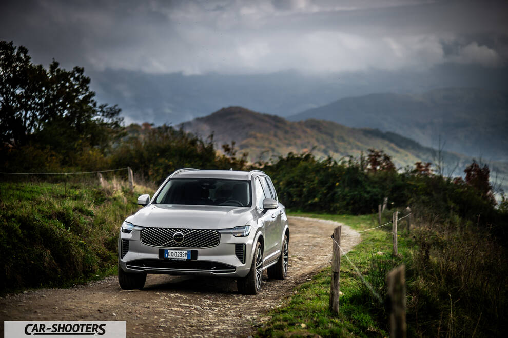 Volvo XC90 2025 – front three-quarter, silver on a dirt road with mountains