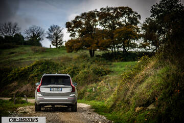Volvo XC90 2025 – rear view, silver on a country road
