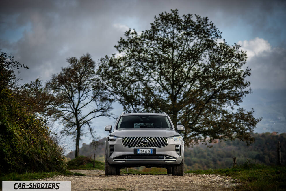 Volvo XC90 2025 – front three-quarter, silver metallic on a country road