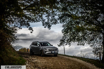 Volvo XC90 2025 – front three-quarter, silver metallic on a country road