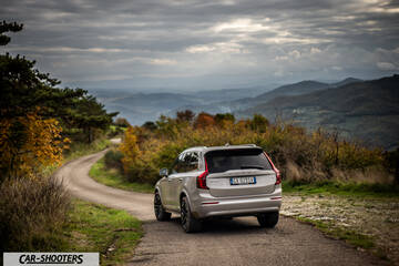 Volvo XC90 2025 – rear three-quarter, silver on a country road
