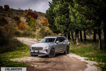 Volvo XC90 2025 – front three-quarter, silver metallic on a country road
