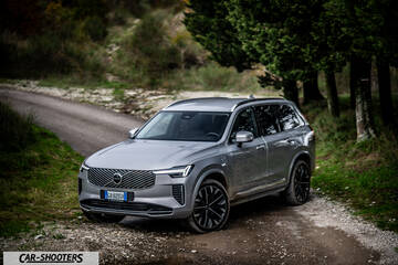 Volvo XC90 2025 – front three-quarter, silver metallic on a country road