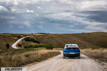 Ford Capri – rear view, blue on a dirt road through rolling hills