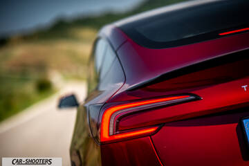 Tesla Model 3 Performance – rear three-quarter, red metallic on a country road