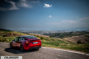 Tesla Model 3 Performance – rear three-quarter, red metallic on a country road