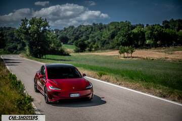 Tesla Model 3 Performance – front three-quarter, red metallic on a country road