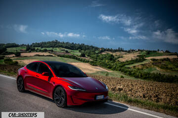 Tesla Model 3 Performance – front three-quarter, red metallic on a country road