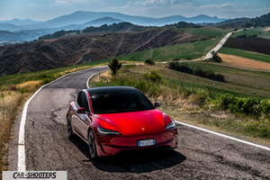Tesla Model 3 Performance – front three-quarter, red on a country road