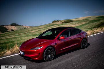 Tesla Model 3 Performance – front three-quarter, red on a country road