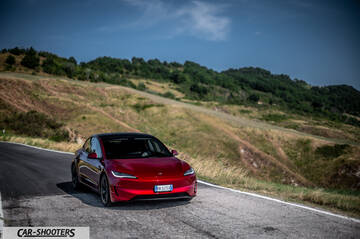 Tesla Model 3 Performance – front three-quarter, red metallic on a country road