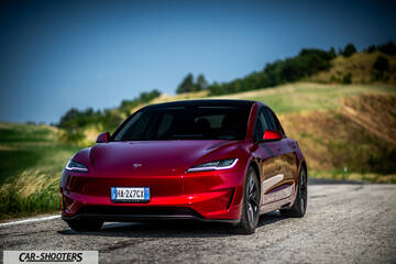 Tesla Model 3 Performance – front three-quarter, red metallic on a country road