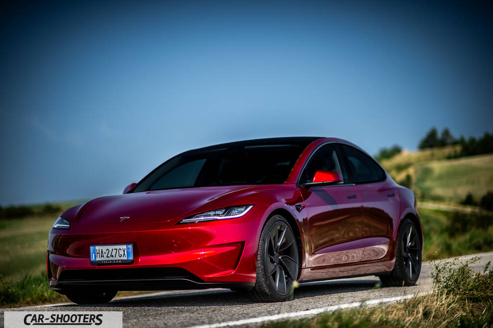 Tesla Model 3 Performance – front three-quarter, red metallic on a country road