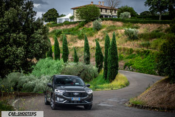 Ford Kuga 2025 – front three-quarter, dark grey metallic on a country road